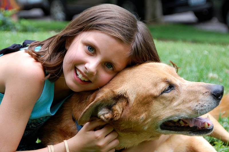 girl cuddling dog