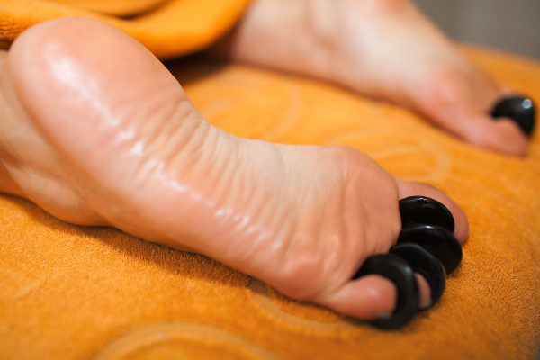 Hot Stone Reflexology on orange towel