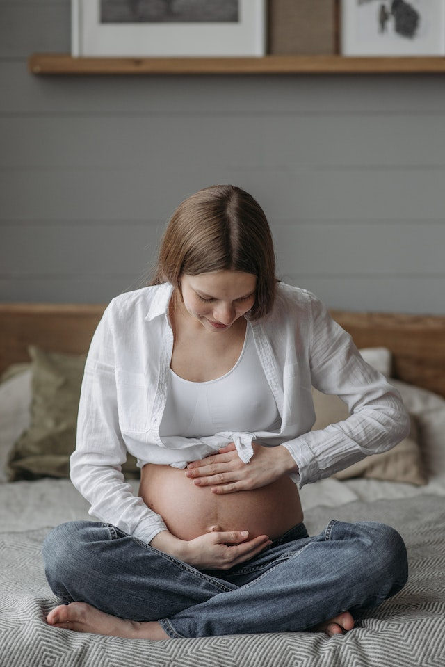 Pregnant Lady Sitting On Bed